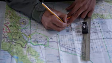 Un membre de l'armée de l'air malaisienne tente de retrouver la trace du Boeing 777 sur une carte marine, le 14 mars 2014.
