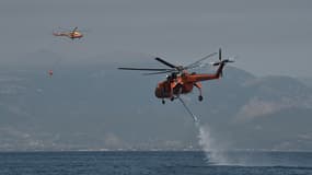 Un hélicoptère Sikorsky S-64 Skycrane fait le plein d'eau lors de la lutte contre le feu près de la plage de Lambiri à Patras, le 1er août 2021. (PHOTO D'ILLUSTRATION)