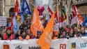 Des manifestants à Dijon le 7 mars 2023 derrière une bannière de l'intersyndicale 