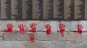 Des mains rouges taguées sur le Mur des Justes au Mémorial de la Shoah à Paris le 14 mai 2024