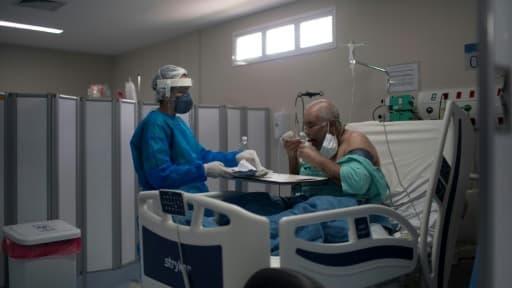 Un infirmière apporte un plateau à un malade du Covid dans un hôpital de Marica City, dans l'état de Rioo au Brésil, le 5 juin 2020. Un infirmière apporte un plateau à un malade du Covid dans un hôpital de Marica City, dans l'état de Rioo au Brésil, le 5 juin 2020.