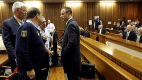 L'athlète Oscar Pistorius parle avec ses avocats le 4 mars, au lendemain de la reprise de son procès.