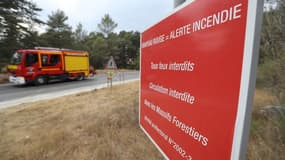 Un camion de pompiers passe à côté d'un panneau signalant le risque d'incendies dans le Sud de la France (image d'illustration)