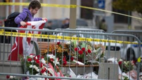 Des Canadiens rendent hommage au soldat tué devant le monument aux morts au cours de la fusillade, le 23 octobre, à Ottawa.