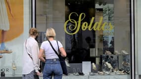 Deux femmes devant la vitrine d'un magasin de chaussures pendant les soldes, le 24 juin 2022 à Paris