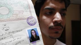 Hassan Khan montre un document avec une photo de sa défunte femme, Zeenat Bibi. 
