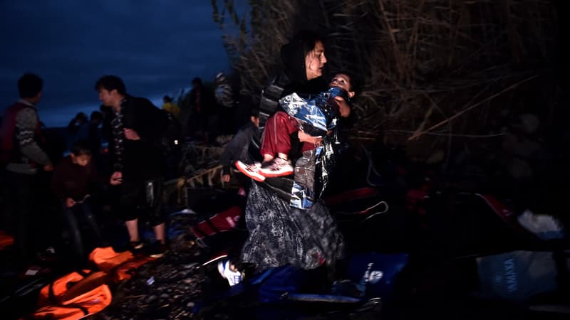 Une femme porte son enfant après une traversée éprouvante entre la Turquie et la Grèce, le 24 octobre 2015 - Photo d'illustration