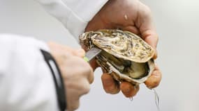 Un employé ouvre une huître au pavillon de la marée du marché de Rungis, le 6 décembre 2022 au sud de Paris