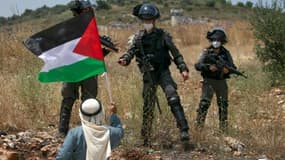 Un Palestinien fait face à des forces de sécurité israéliennes pendant une manifestation contre le projet d'annexion israélien, près de Tulkarem, dans le nord de la Cisjordanie occupée, le 5 juin 2020