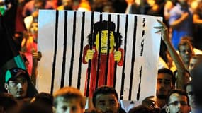Caricature de Mouammar Kadhafi lors d'un rassemblement à Benghazi pour célébrer l'entrée des rebelles dans la capitale libyenne Tripoli. L'Union européenne appelle le dirigeant libyen Mouammar Kadhafi à démissionner "sans délai" et indique que les prépara