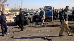 Soldats américains et forces de sécurité irakiennes sur les lieux d'un double attentat lundi à Ramadi, à l'ouest de Bagdad. Les attaques, qui visaient un bâtiment officiel, ont fait au moins 17 morts et une cinquantaine de blessés dans cette ville du cent