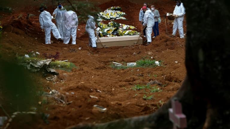 Un cercueil avec la dépouille d'une personne décédée du Covid-19 est mis en terre au cimetière de Vila Formosa, à Sao Paulo, au Brésil, le 14 avril 2021
