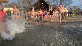 Les participants du traditionnel bain de Noël à la ballastière de Bischheim se jettent à l'eau le 25 décembre 2024