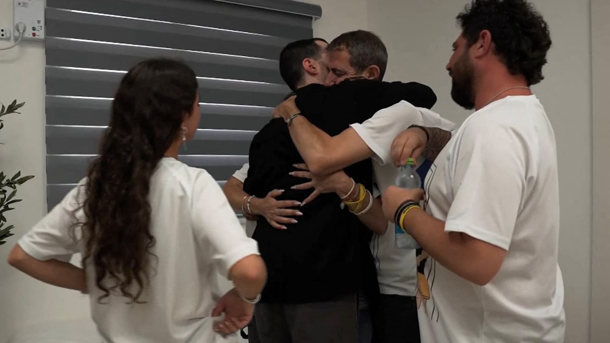 Cette photo diffusée par l'armée israélienne montre Guy Gilboa-Dalal, l'un des otages israéliens, être embrassé par un membre de sa famille lors de sa libération le 13 octobre 2025.