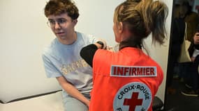 Un membre de la Croix-Rouge française vaccine contre la méningite un étudiant du campus de l'école de commerce de Rennes, le 3 mars 2025.