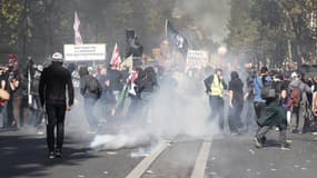 Des black blocs face aux gaz lacrymogènes des policiers lors de la marche pour le climat