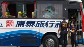 Enquêteurs à bord de l'autocar où s'est déroulé une prise d'otages lundi à Manille. Les autorités philippines défendent leur gestion de cette prise d'otages qui s'est terminée dans un bain de sang avec la mort de huit touristes originaires de Hong Kong. /