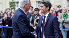 Michel Barnier sert la main du Premier ministre sortant Gabriel Attal lors de la cérémonie de passation de pouvoir à l'Hotel Matignon à Paris, le 5 septembre 2024 