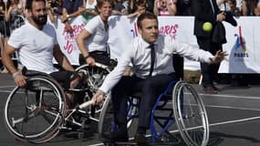 Emmanuel Macron s'essaye au tennis en fauteuil pour promouvoir la candidature de Paris aux Jeux Olympiques 2024, à Paris le 24 juin 2017.