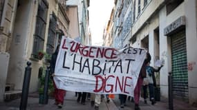 Des habitants de Marseille brandissent une pancarte "L'urgence c'est l"habitat digne", le 5 novembre 2018 après l'effondrement des bâtiments de la rue d'Aubagne.