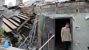 Un homme se tient dans les décombres d'une maison touchée par le bombardement à Donetsk.