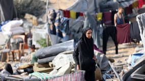 Une femme palestinienne marche parmi des tentes dévastées, après une frappe israélienne nocturne qui a endommagé les abris temporaires, à Gaza, le 13 septembre 2025.