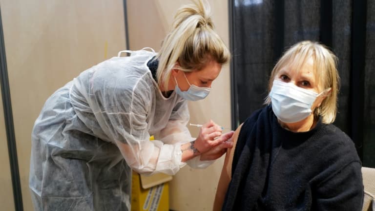 Une femme sapeur pompier vaccine une patiente, à Vailhauques (sud de la France), le 13 mars 2021.