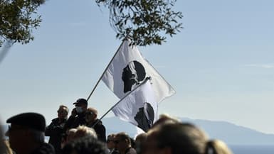 La bandera à la tête de maure, l'emblème corse, dans la foule attendant d'assister aux funérailles d'Yvan Colonna à Cargèse, en Corse-du-Sud, le 25 mars 2022