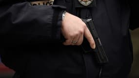 Un officier de police tient son arme à la main, image d'illustration.