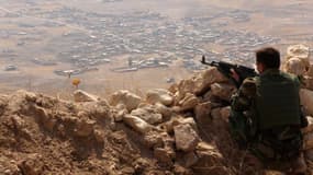 Un Kurde irakien Peshmerga surveille les environs sur le mont Zardak, à 25 kilomètres à l'est de Mossul