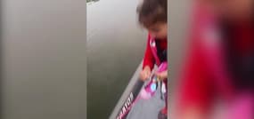 Une petite fille attrape un poisson avec sa canne à pêche Barbie : 