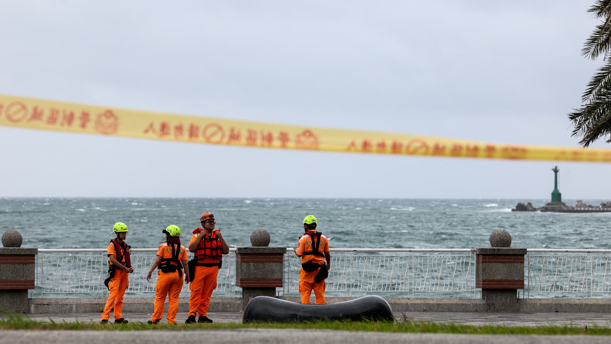 Les membres des garde-côtes taïwanais travaillent le long de la côte alors que le typhon Podul approche Taïwan, à Kaohsiung, le 13 août 2025.