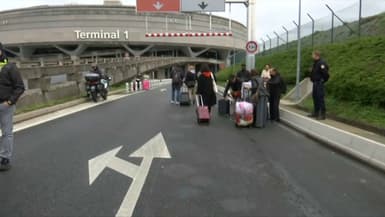 Des voyageurs se rendent à pied à l'aéroport de Roissy après une action de la CGT
