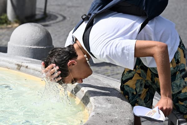 Un homme se verse de l'eau sur la tête pour se rafraîchir à la fontaine de la Piazza del Popolo à Rome, le 18 juillet 2023.