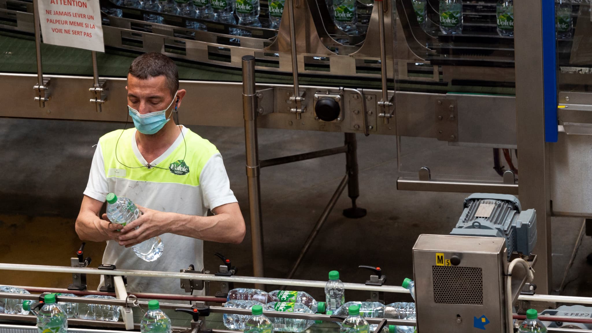 Un ouvrier masqué sur une ligne de production de l'usine Volvic en mai 2021. Un ouvrier masqué sur une ligne de production de l'usine Volvic en mai 2021.