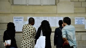 Professeurs et lycéens regardent les résultats du bac au lycée Voltaire à Paris, le 4 juillet 2023.