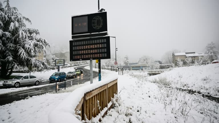 Un écran affiche le message "Equipement spécial obligatoire" sur le bord d'une route après une chute de neige à Saint-Etienne, dans le sud-est de la France, le 15 mars 2025