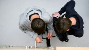 Des élèves déposent leurs téléphones portables dans un casier (illustration)