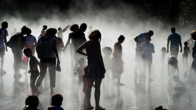 Enfants et parents se rafraichissent près d'une fontaine à Nantes le 26 août 2016.