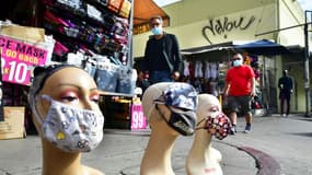 Des passants portant un masque marchent le long de mannequins portant aussi des masques, à Los Angeles, Etats-Unis, le 10 novembre 2020