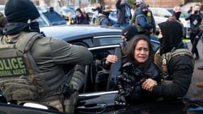 Les agents de l'ICE arrêtent une femme après l'avoir fait sortir d'une voiture le 13 janvier 2026 à Minneapolis, dans le Minnesota.