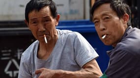 Deux travailleurs en train de fumer en travaillant. La Chine consomme plus d'un tiers de la production mondiale de cigarettes.