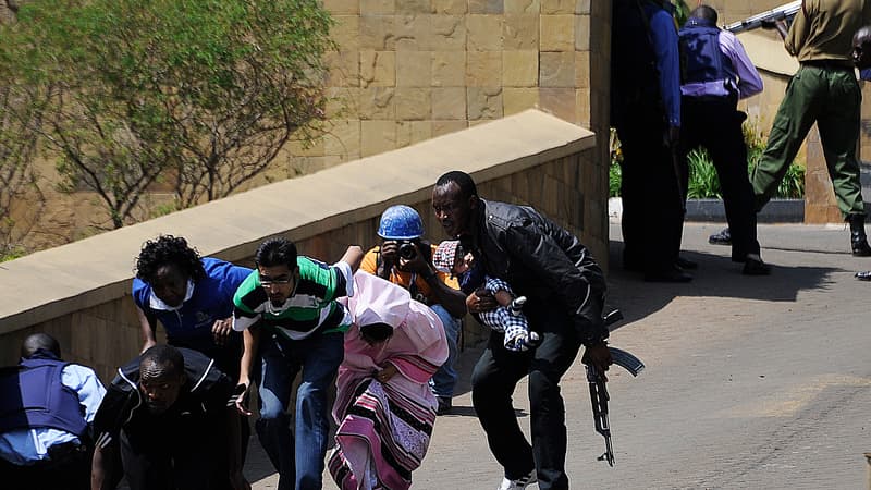 Des policiers évacuent des clients du centre commercial, samedi après-midi, à Nairobi.