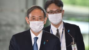 Le nouveau Premier ministre japonais Yoshihide Suga(g), le 16 septembre 2020 à son arrivée à son bureau à Tokyo