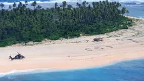 Photo prise par l'armée australienne d'un hélicoptère se posant près du "SOS" géant écrit sur le sable par trois naufragés sur l'îlot Pikelot, dans le Pacifique.