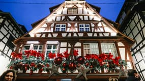 Des visiteurs passent devant une maison décorée pour Noël, le 27 novembre 2024 à Strasbourg, dans le Bas-Rhin