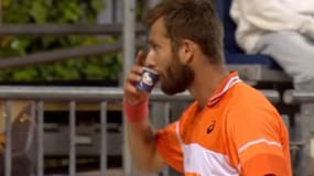 Le Français Corentin Moutet boit un café lors de son match au Masters 1000 de Madrid, 24 avril 2024