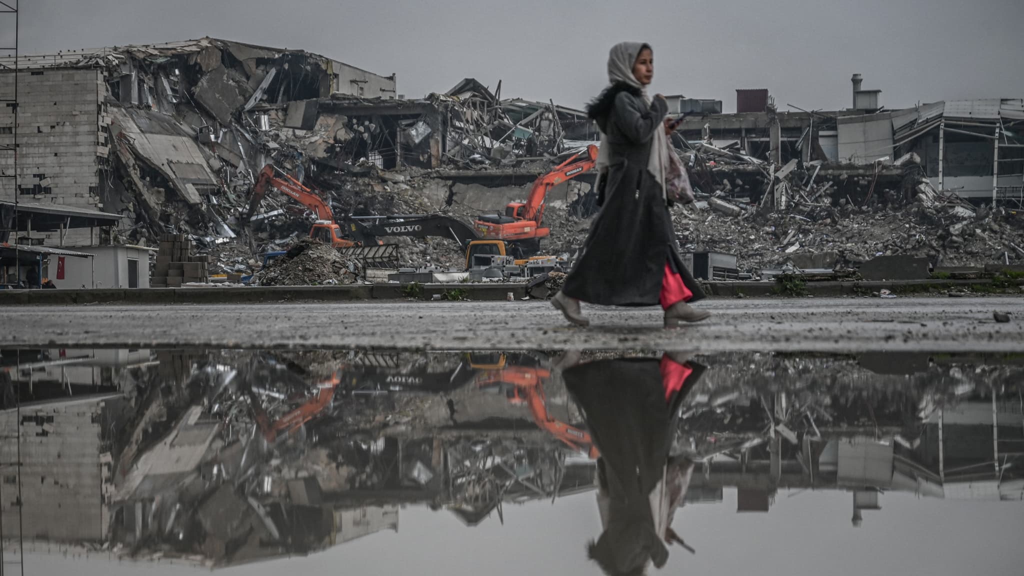 Une femme marche devant les décombres d'habitations, un an après les séismes en Turquie et en Syrie, le 12 janvier 2024 à Antakya, en Turquie Une femme marche devant les décombres d'habitations, un an après les séismes en Turquie et en Syrie, le 12 janvier 2024 à Antakya, en Turquie