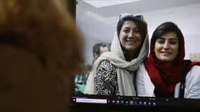 Une femme regarde une photo des journalistes iraniennes Niloufar Hamedi et Elaheh Mohammadi postée sur Twitter, à Nicosie le 2 novembre 2022