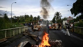 Des véhicules brûlés bloquent une route à Sainte-Rose, le 30 novembre 2021 en Guadeloupe